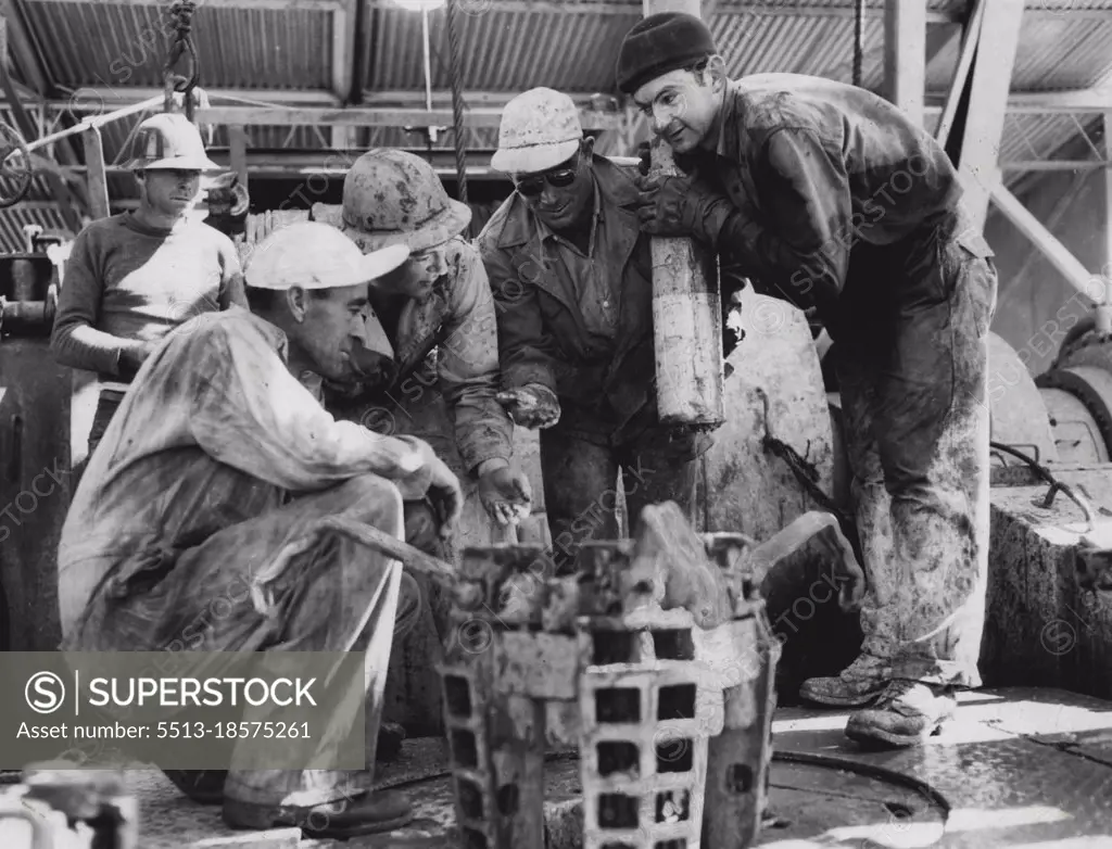 A drilling crew on the Rough Range No. 1 oil rig in Western Australia examine pieces of a broken drill after a successful "fishing" operation. The men used a magnet to retrieve the broken pieces from a depth of 9,908 feet. The welll is the exploratory one which yielded oil last year. West Australian Petroleum Pty. Ltd. has announced that No. 2 well has failed to produce oil at the horizon at which it was discovered in No. 1 well. August 05, 1954.