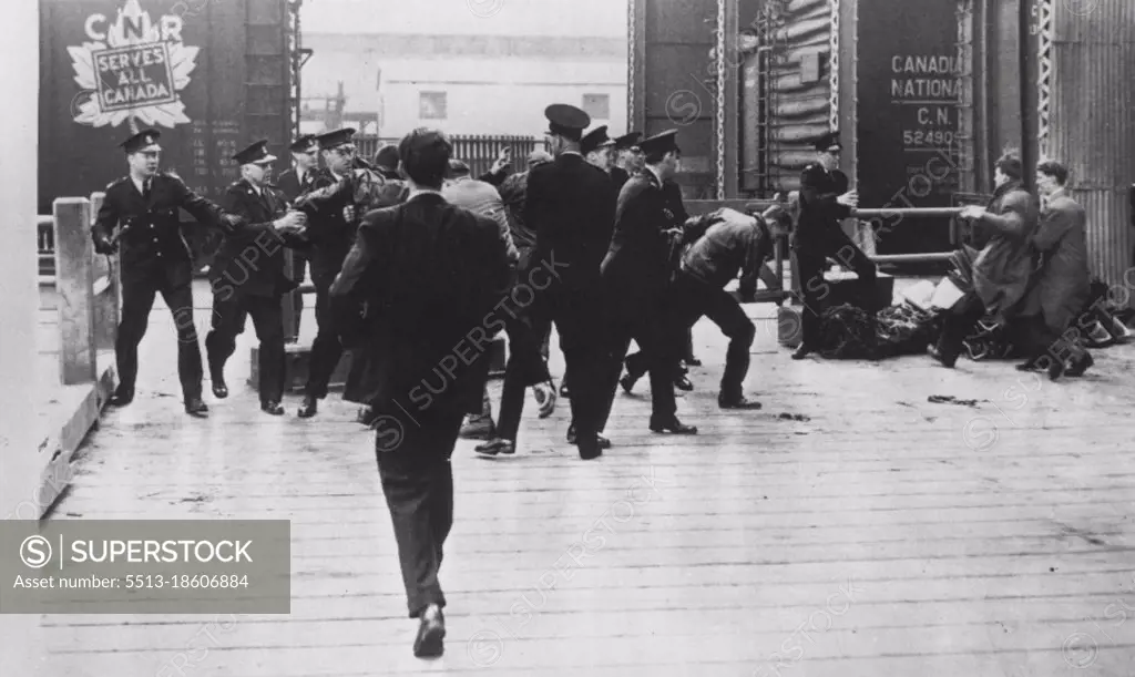 Police and Pickets Clash -- Members of Canadian Seamen's Union Scuffle with police in attempt to board the SS Riverside here this morning in vain effort to keep Seafarers' International Union men from boarding. SIU members climbed rope ladders seaward side, pulled up gangplank, and readied ship for sailing. May 12, 1949. (Photo by AP Wirephoto). 