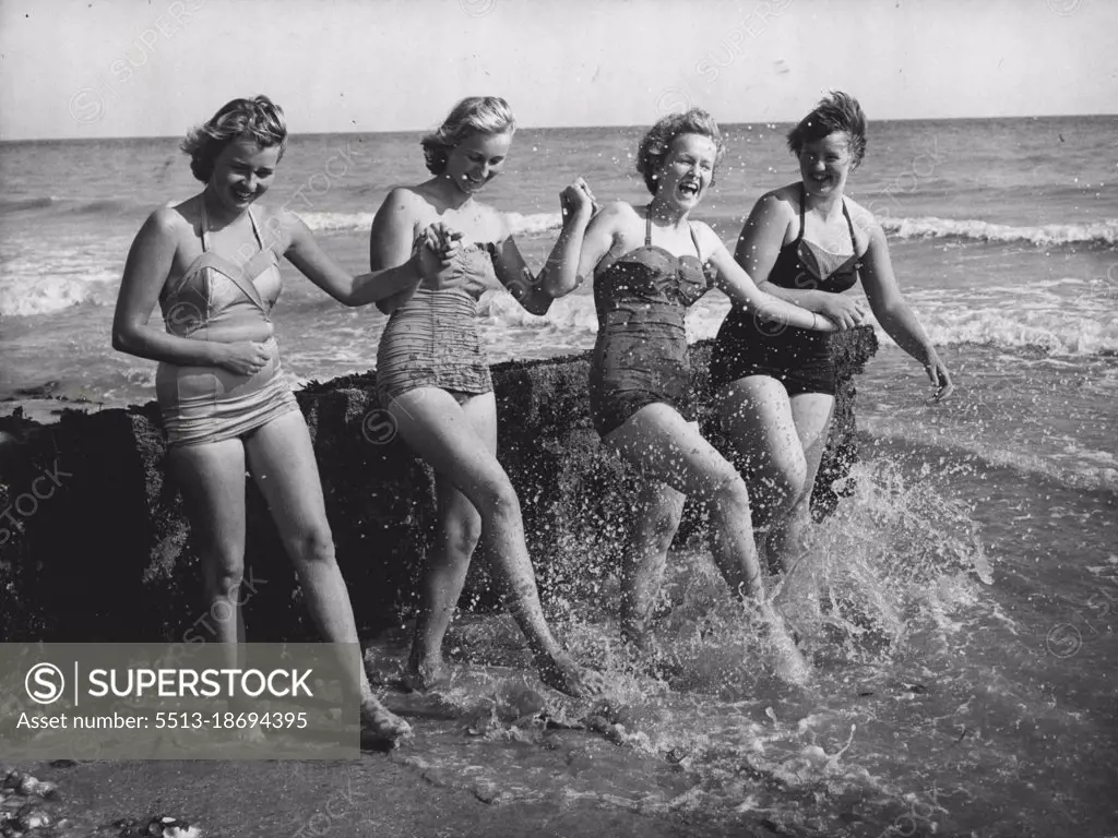 "The Sea Is So Cold" Say The Girls From Iceland -- Enjoying themselves on the beach at Bexhill, Sussex, are four girls from Iceland who are attending a summer school at Bexhill to perfect their English. Their only complaint is that they find the sea very cold after Iceland is summer temperature! From left to right are: Ruth Ragnarsdottir, 18; Gudrun Magnusdottir, 15, Gudrum Kristinsdottir, 15; and Sigridur Gudmundsdottir, 16. August 17, 1955. (Photo by Reuterphoto).