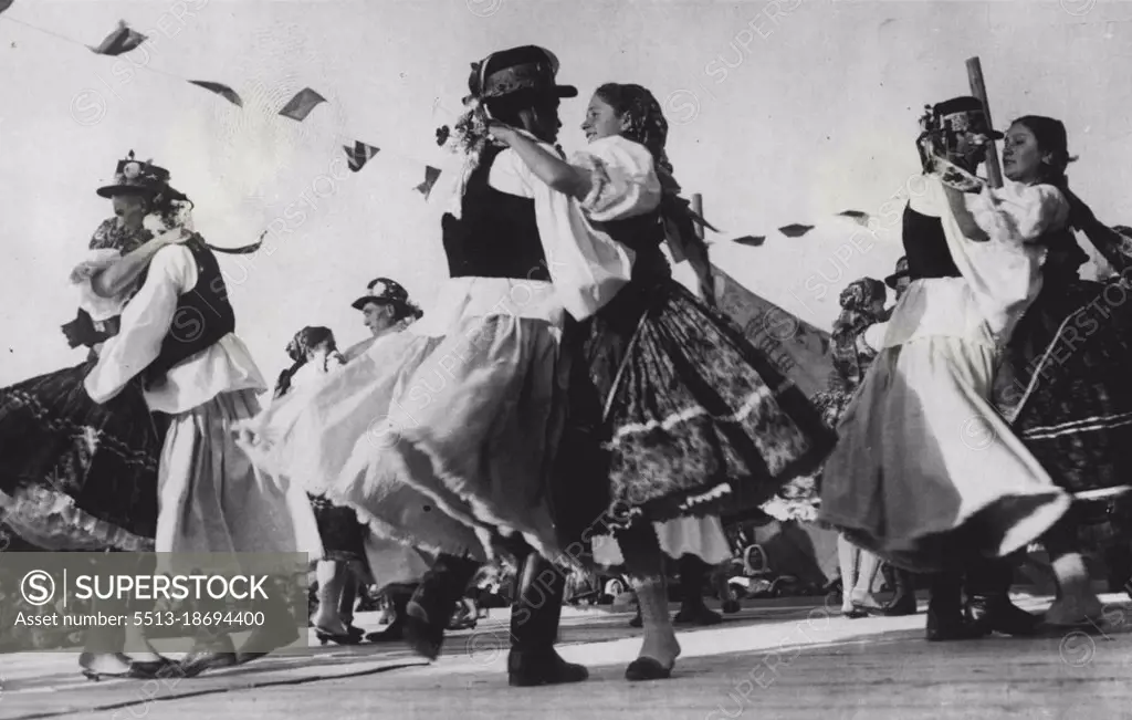 ***** Hungary: ***** the vigour of life is seen in the whirling exciting ***** the Czardas. Hungary's National dance and danced here ***** and girls in their quaint national costumes. As the ***** faster and crowd get more excited and clap and shout. November 25, 1935. (Photo by Keystone).