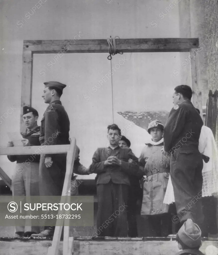 Former Nazi official Hanged -- Franz Strasser (center) stands with hands folded just before he was hanged at Landsberg, Germany, December 10, for killing two American fliers forced down in Germany during the war, Johann Reichart, German executioner, is just behind Strasser. Col. T. N. Griffin, (far left), U.S. third army provost Marshal, reads charges against Strasser for last time. January 21, 1946. (Photo by AP Wirephoto).