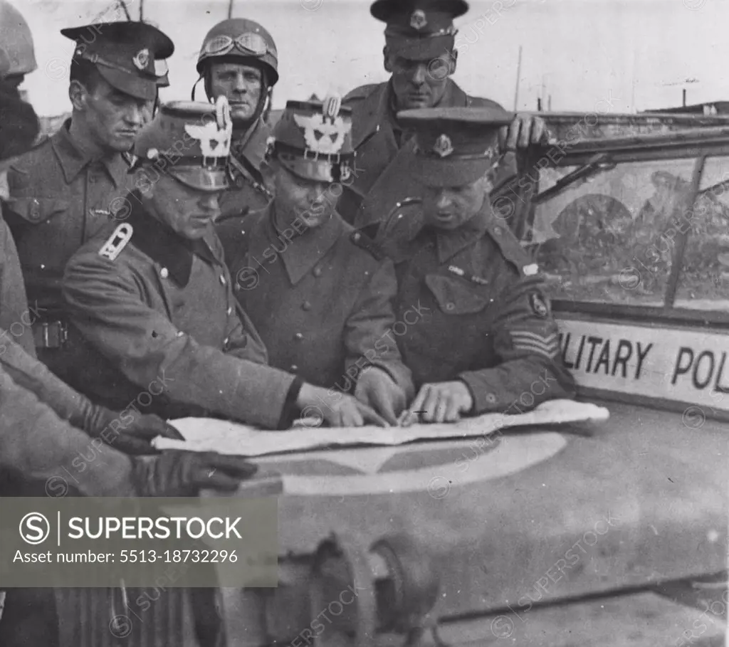 British Troops Enter Hamburg -- British military policeman giving ***** to German policemen in Hamburg. June 25, 1945. (Photo by British Official Photograph)