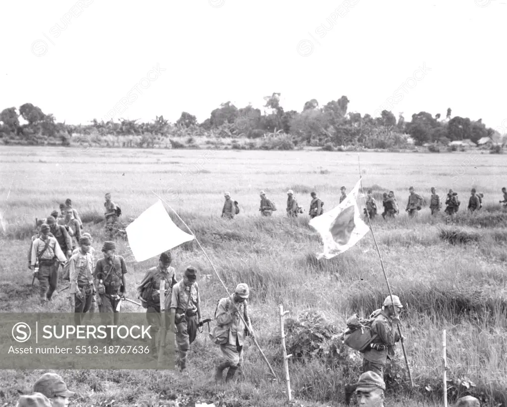 Japs Surrender At Bataan - A serpentine column of surrendering Japanese soldiers cross a green rice paddy as they approach waiting 38th Div. troops. Fifty officers and 400 men, all that remained of more than 6,000 enemy troops, surrendered at Orion and Bagac, Bataan. They are shown moving along the same trail over which Americans made the infamous "death march" in 1942. This enemy force, under Col. Nagayoshi was completely defeated in battle by veteran 38th Div. troops in their reconquest of historic Bataan peninsuls. April 9, 1945. (Photo by U.S. Army Photo).