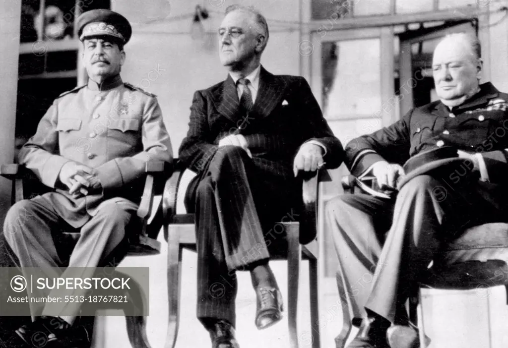 Principals At Teheran Conference -- Joseph Stalin, Russian premier (left), sits with President Franklin D. Roosevelt of the United States and Prime Minister Winston Churchill (right), on the porch of the Russian Embassy at Teheran, Iran, during their four-day conference at which they drew plans to concentrate the total military might of Russia, United States and Britain on a "Relentlessly Increasing" Basis Guaranteeing victory over Germany. This is one of a series of photos on the conference made by U.S. Army 12th Air Forces photographers and pleased by the War Department in Washington. December 05, 1943. (Photo by Associated Press Photo).