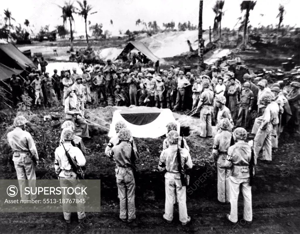 Japanese Colors Cover General's Casket -- Marines prepare to lower the casket, containing the body of Lieut, Gen. Yoshiko Saito of the Japanese Imperial Army, into a grave on Saipan. The casket is covered with a large Japanese flag. August 7, 1944. (Photo by Official U.S. Marine Corps Photo).