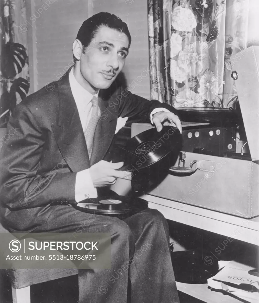 Brideless Groom Amuses Self With Phonograph -- Riad Ghali Egyptian commoner who married Egyptian Princess Fathia in a Civil ceremony  April 25, passes the time playing his portable phonograph. Princess Fathia and Ghali have been living in separate hotel suites until a second marriage is performed under Moslem faith. The date for the Moslem ceremony has not been announced. May 18, 1950. (Photo by AP Wirephoto).