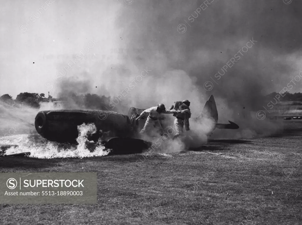 Saving The Pilot - The aircraft is ablaze, the 'pilot' is unable to extricate himself, but men of the Royal Naval Air Station Anthorn come to his rescue. The 'pilot' is only a dummy, but the naval airmen who performed the task at a demonstration at the School of Aircraft Handling, Gosport, Hampshire (known in the Royal Navy as HMS Siskin), showed how valuable lives can be saved. June 28, 1952. (Photo by Reuterphoto).