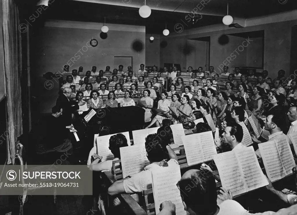 La Scala Strike Ends -- The La Scala choir in rehearsal under its conductor and trainer Veneziani.The Chorus and Orchestra of La Scala, Milan, ended their ten day strike on Wednesday.The strike concerned their right to make recordings. They have agreed to work exclusively for the Opera House from January 1, 1953.Sir Thomas Beecham was to have conducted a concert in La Scala last week but this had to be cancelled on account of the strike. October 17, 1952. (Photo by Paul Popper).