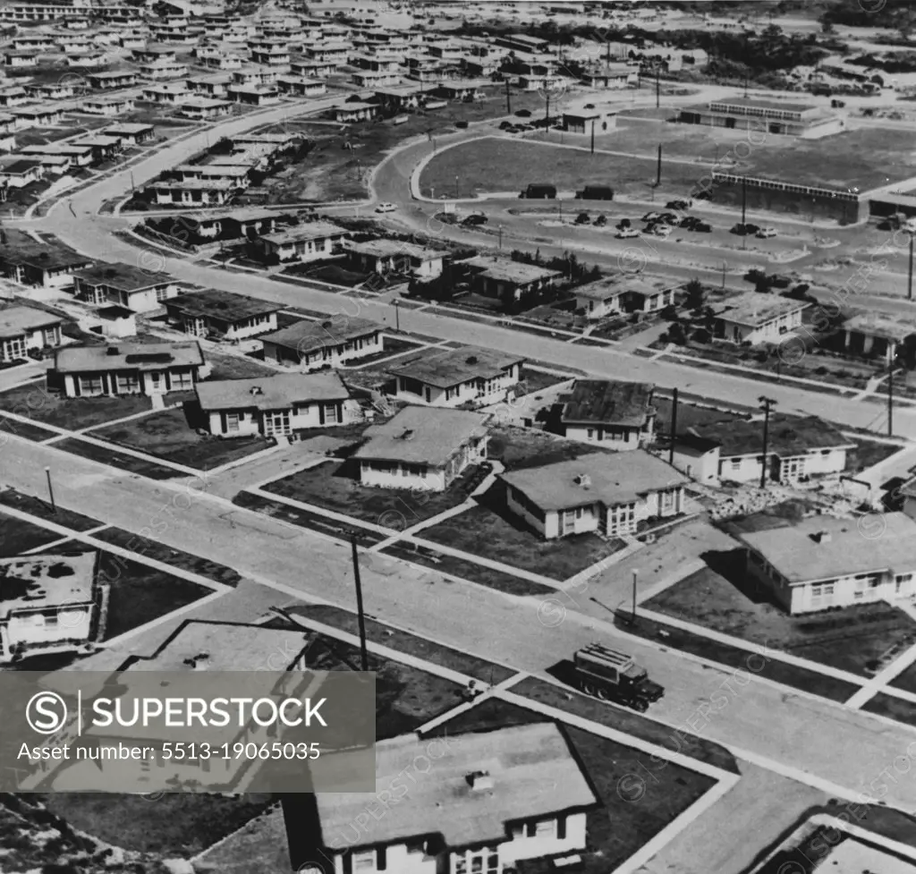 Okinawa: Ten Years Later -- This is the Okinawa U.S. troops stationed there know today. The aerial view shows a section of the suburban-like dependent-housing area at Sukiran. The homes are concrete typhoon-proof structures. The buildings at upper right house the commissary, bank and post office. May 06, 1955. (Photo by U.S. Army Photo).