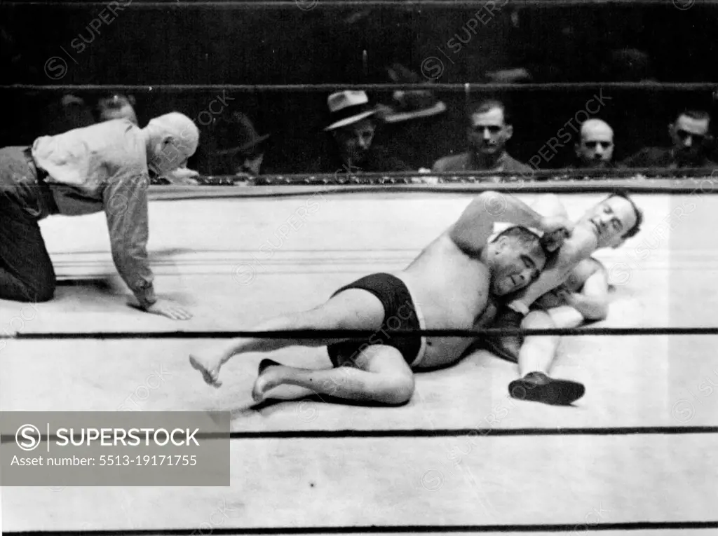 Strangler Lewis Retains Title -- Ed (Strangler) Lewis, World's Heavyweight Wrestling Champion, had no difficulty defending his crown against the assault of Dr. Fred Meyers, Chicago's Rappler-Dentist, in Madison Square garden, New York City, night of February 6. Lewis pinned the shoulders of his Rival in 25 minutes, 27 seconds. In the Above Photograph, thing looked bad for a moment for Lewis, (Left), When Meyers got an Arm lock on the Champion. February 6, 1933. (Photo by Associated Press Photo).