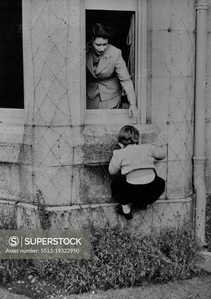 Mountaineering At Balmoral :H.R.H. Prince Charles is seen in his attempt, which he successfully accomplished, to climb in through one of the windows of Balmoral Castle. H.M. The Queen stands at the open window ready to give her small son a helping hand, should it be required. May 1, 1953. (Photo by Fox Photos).