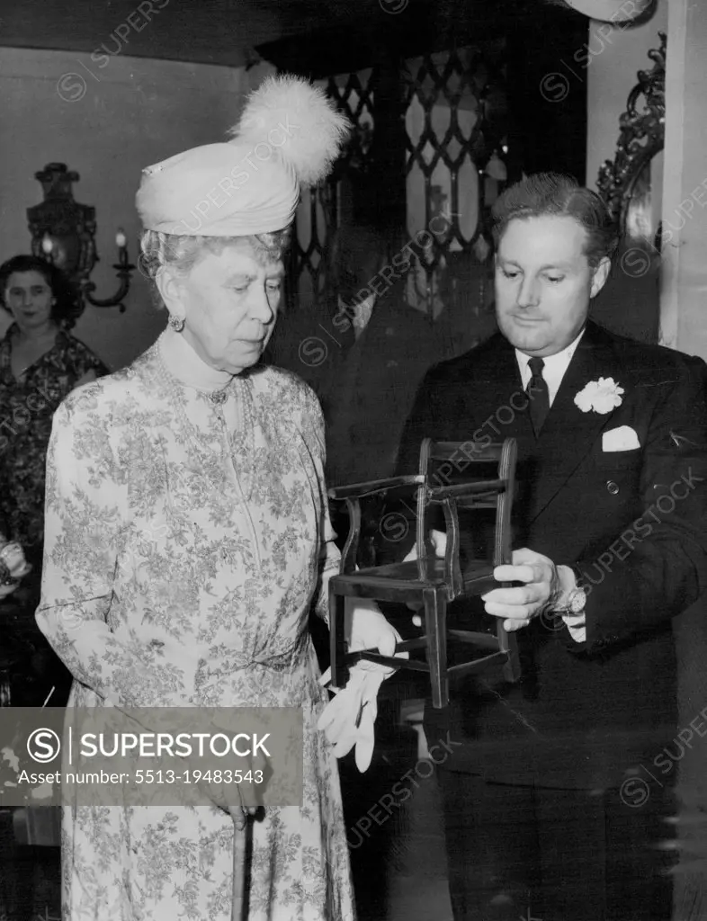 Queen Mary Visits Antiques Show -- Queen Mary, who has a great interest in antiques, is shown a miniature Sheraton chair by Mr. C. Toller of Marlew, Buckinghamshire, as she visits the Eleventh Antique Dealers ' Fair in the Great Hall, Grosvenor House, Park Lans, London, today (Friday). (Thomas Sheraton was the last of the great English cabinet-makers of the 18th century). June 15, 1951. (Photo by Reuterphoto).