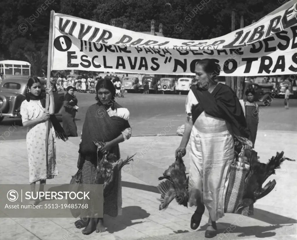 Their Mite For Mexico -- Two Indian women of Mexico, one Barefoot, bring their gifts-chickens-to donate to their country to help pay off the Government debt contracted with the expropriation of the $400,000,000 foreign-owned oil industry of Mexico. These were among thousands Mexican women in a donation parade at Mexico city. The sign reads: "Live to be free, or die to cease being slaves", and is signed--"We the women". April 14, 1938. (Photo by Associated Press Photo).