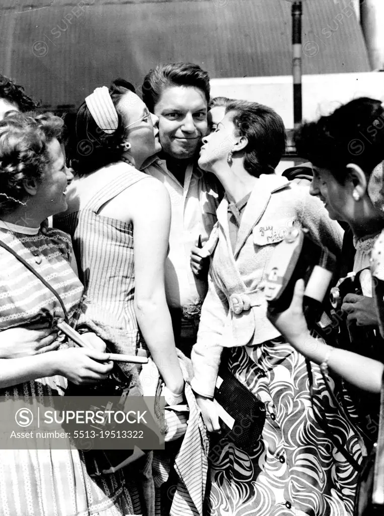 Feminine Hearts fluttered as American sing-ing star, Guy Mitchell greeted his fans at London Airport. He arrived by BOAC for a concert at the Palladium. August 16, 1955.