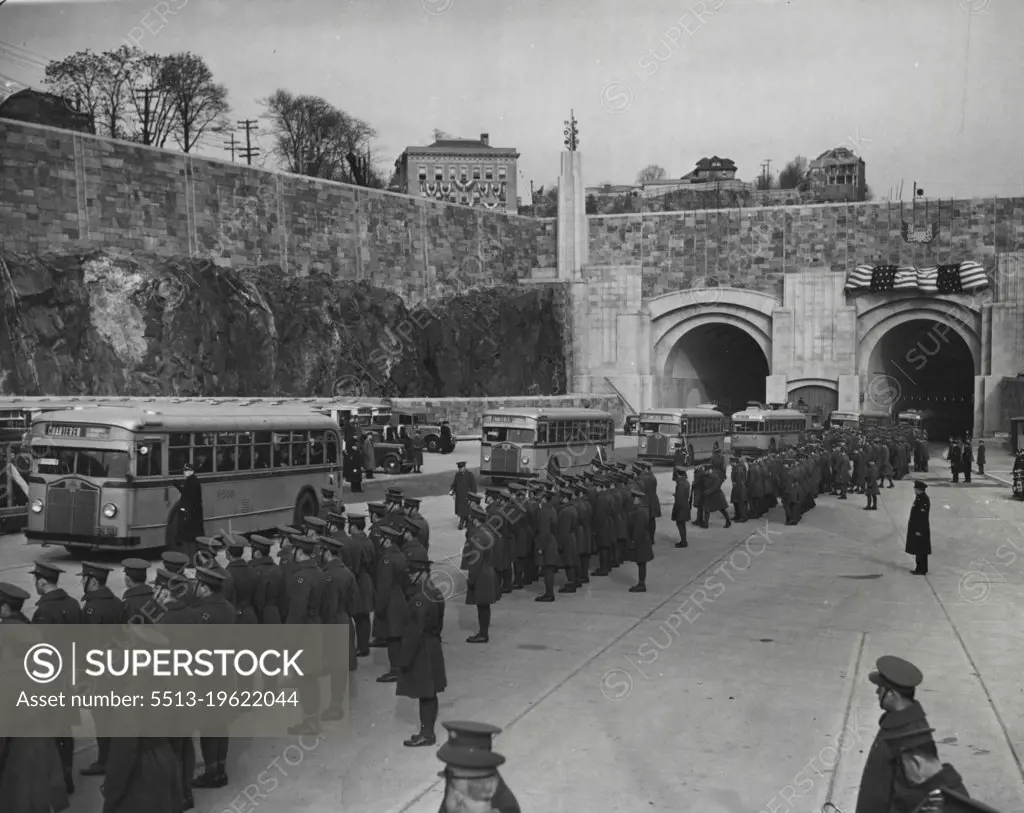 Parade Opens New Manhattan Gateway --  Here is a parade of buses emerging from the new Lincoln Tunnel connecting New Jersey with mid-town New York City as dedication ceremonies for the south tube were held Dec. 21. Shown here is the Jersey portal of the new Subhudson vehicular route. Troops are lined up along the roadway as the buses which carried buses which carried 1,500 through the tunnel emerge. December 21, 1937. (Photo by Associated Press Photo).