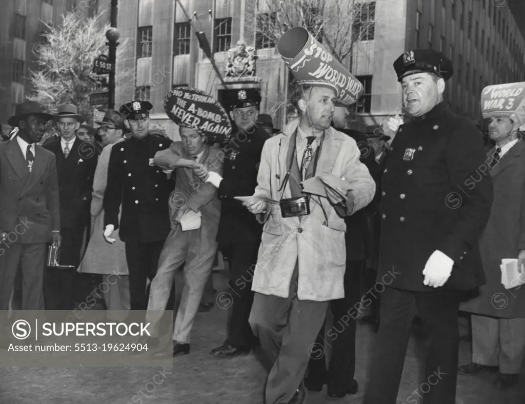 Anti-war pickets taken from Easter Parade -- Police hustle two of a group of anti-war pickets from the Easter Sunday parade at fifth avenue and 50th Street. The group, wearing hats with anti-war slogans, joined the parade before St. Patrick's Cathedral until police broke up the demonstration. One of the pickets had to be carried from the scene by police. April 17, 1949. (Photo by Associated Press Photo).