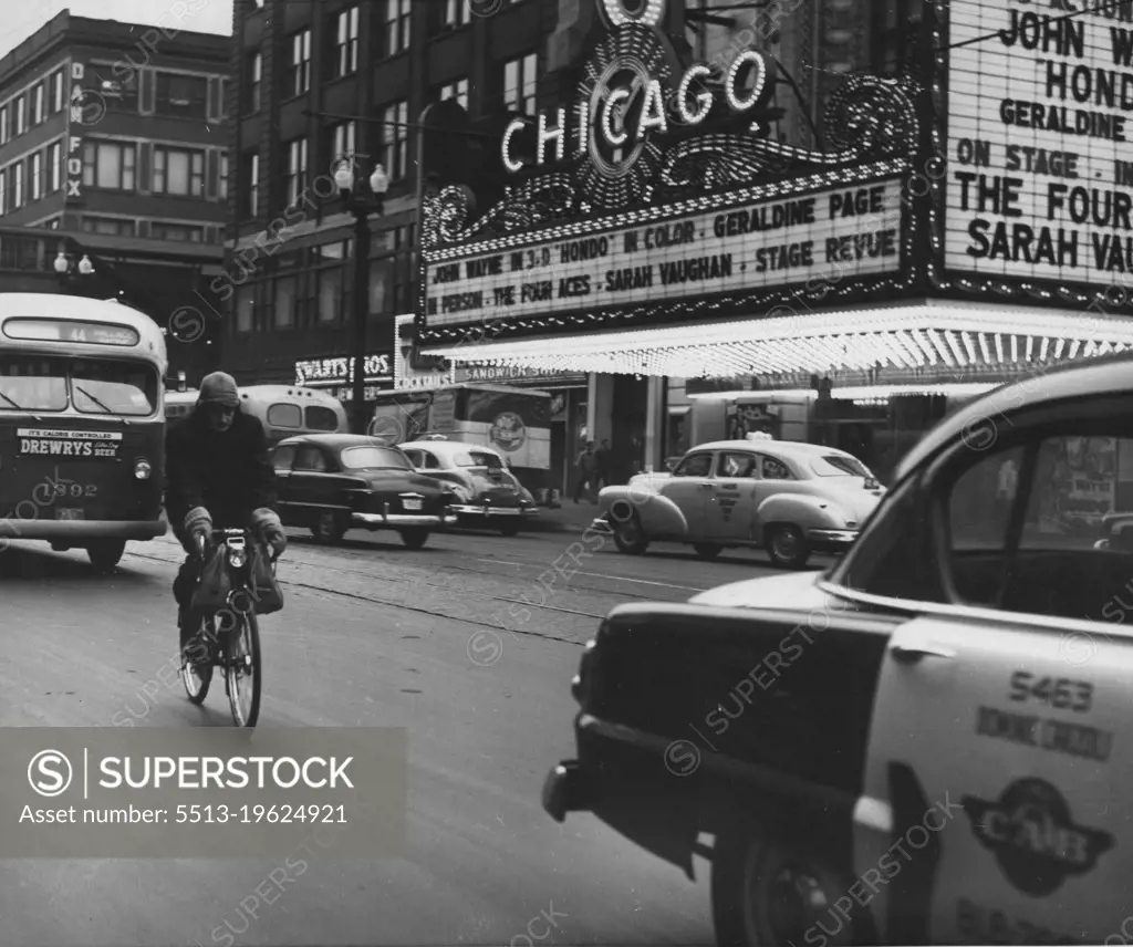 Bronson, dressed for zero weather, breezed along nonchalantly down state street, totally unconcerned about the traffic congestion. December 30, 1955. (Photo by United Press).