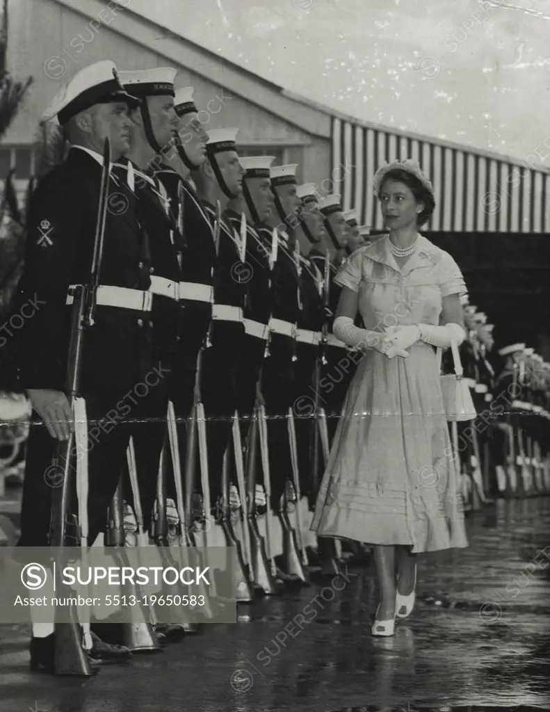 Attention - The Queen has a satisfied smile as she inspects the naval guard of honor immediately after arrival. True to navy tradition the guard stands strictly to attention, and although the Queen smiles not a muscle moves on the faces of the guard. December 23, 1953.