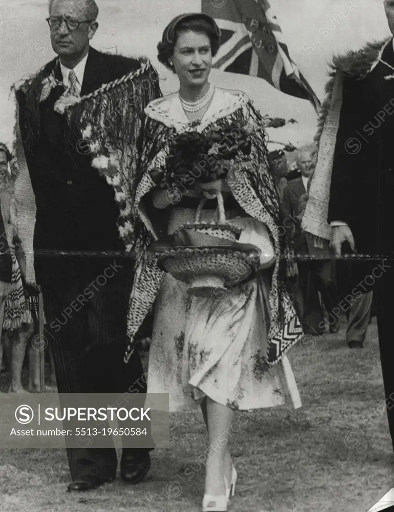 Gifts - Queen Elizabeth ***** charming and happy as she leaves a Maroi ceremony at Arawa Park, Rotorua, in a Maori chief's cloak. The Queen is carrying gifts of flowers and two baskets. January 07, 1954.