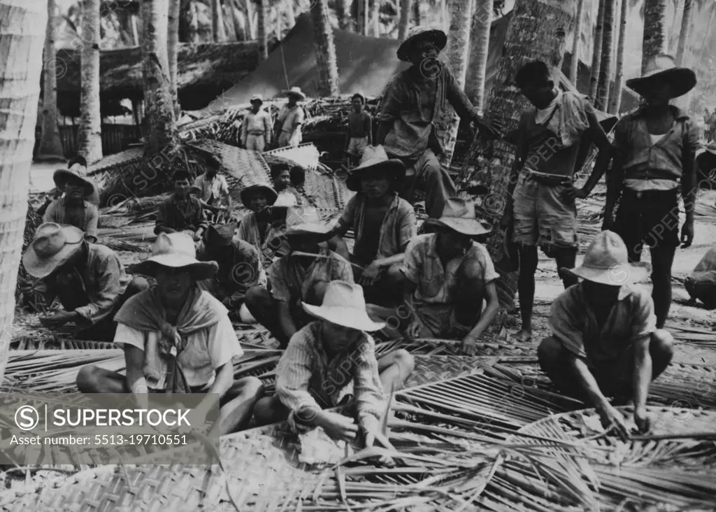 Weaving Material For New Barracks -- These Filipinos are ***** at a labor camp west of Pinamopoan, Leyte Island, in weaving material for a new thatch-roof barracks in the area. Palm fronds are being cleverly interlaced in the process, making a comparatively durable material through which air may circulate to improve living conditions in the humid climate. This matting normally covers only half the walls, the upper half being left open or screened in -- if there is any screening available. It is said that these structures, made wholly of vegetation from the jungles, will last native people for at least three years but stand up for white men only about 18 months against the onslaughts of heavy rains and wind and of fungi and wood-devouring insect life.  January 23, 1945. (Photo by U.S. Army Signal Corps Photo).