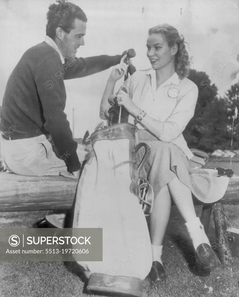 Sweeny and wife at masters -- Robert J. Sweeny, Jr., former British amateur  golf champion, gets a helping hand from his bride in polishing up his clubs  after the first round of