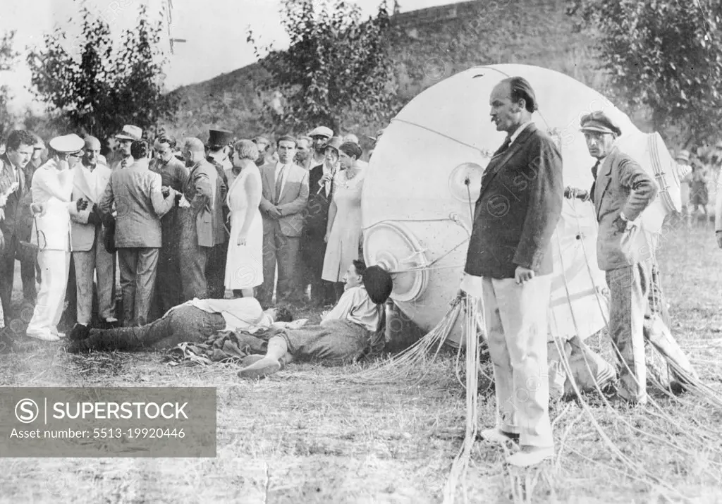 Professor Piccard's Great Adventure In The Stratosphere -- Prof. Piccard and his assistant, M. Cosyns, lying on the ground exhausted just after landing. The change from the intense cold encountered during the journey to the summer heat an landing temporarily prostrated the intrepid scientists.When he and his companion Professor Cosyns landed in Northern Italy they collapsed in the heat after the sub-zero stratosphere temperatures. September 26, 1932.