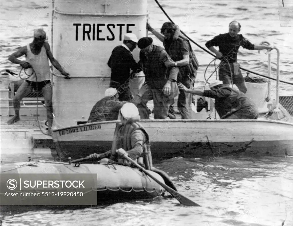 Aided by his 6ft 7in son Jacques he boards a dinghy on their return. September 07, 1955.  (Photo by The Associated Press Ltd.).