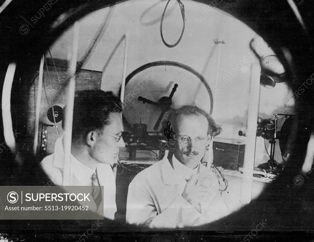 10 Miles Up In A Balloon -- In a hermetically sealed cylinder hanging from a giant balloon, a Swiss scientist today began an attempt to go higher in the air than man has ever gone before. He is Prof. Auguste Piccard, member of the staff of Brussels University, and he hopes to reach a height of ten miles above the earth. He is accompanied by an assistant. The start was made soon after dawn from a field at Augsburg, Bavaria. Prof. Piccard (right) and Dr. Kipfer, his assistant in the balloon ball, testing instruments for the ascent. May 27, 1931. (Photo by Topical Press).