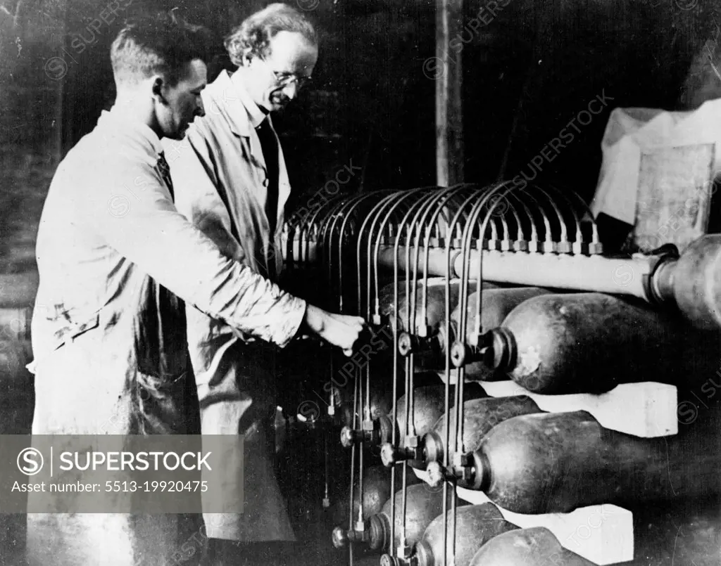 10 Miles Up In A Balloon -- Prof. Piccard testing the gas containers with which the balloon is filled. In a hermetically sealed cylinder hanging from a giant balloon, a Swiss scientist today began an attempt to go higher in the air than man has ever gone before. He is Prof. Auguste Piccard, member of the staff of Brussels University, and he hopes to reach a height of ten miles above the earth. He is accompanied by an assistant. The start was made soon after dawn from a field at Augsburg, Bavaria. May 27, 1931. (Photo by Topical Press).