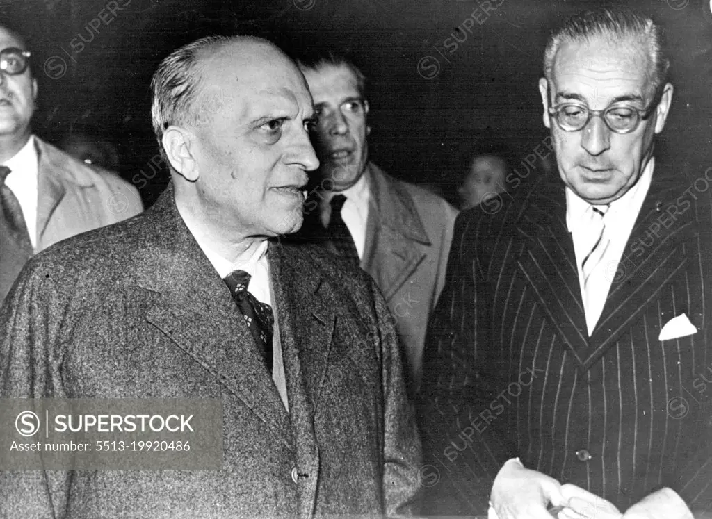 Brussels Is The Scene -- The eyes of the diplomatic world are now centered Brussels, where the six-power conference on the European Defence Community begins today. This picture shows the Italian F.M., Signor Piccioni welcomed by the Italian Ambassador in ***** arrival at the airport. August 19, 1954.