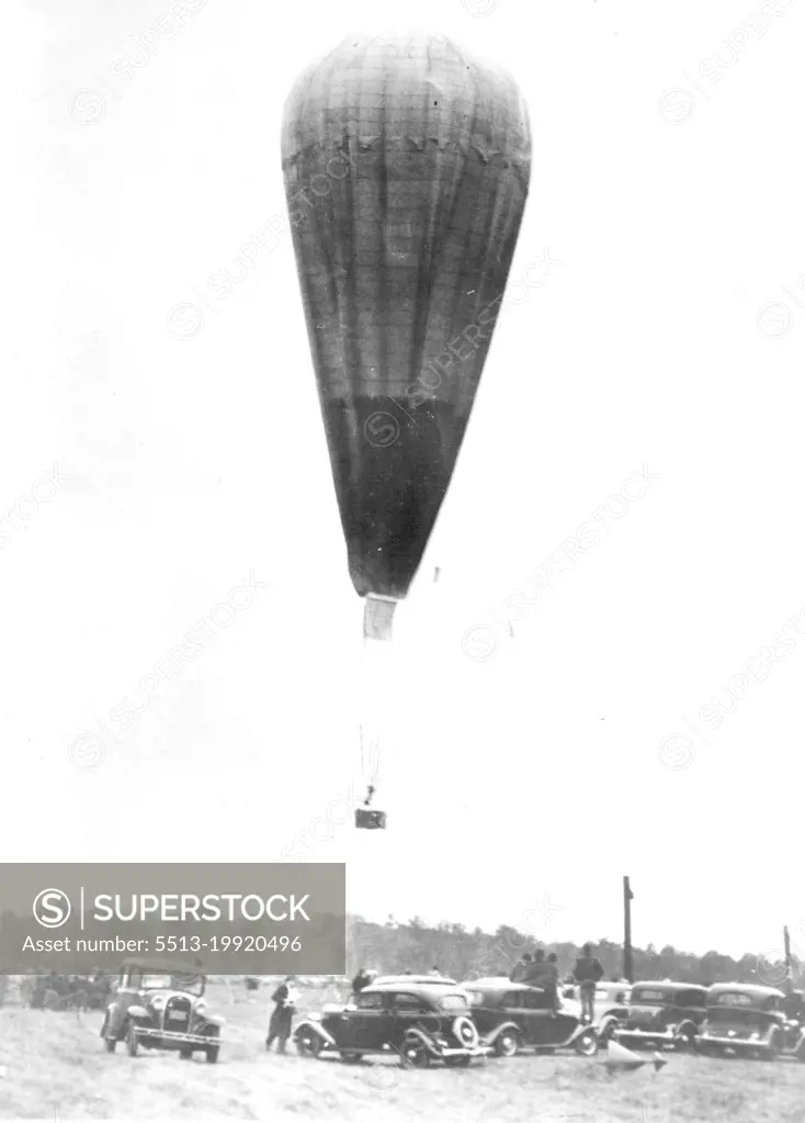 Aloft On Stratosphere Flight -- The wind had died to absolute calm as the balloon of Prof. and Mrs. Jean Piccard was cast off on its flight into the upper air Oct 23. The picture shows the big bag, which had a capacity of 600,000 cubic feet of hydrogen gas, as it left the ground at the ford Airport, near Detroit. The balloonists landed several hours later near Cadiz Ohio, unhurt. October 23, 1934. (Photo by Associated Press Photo).