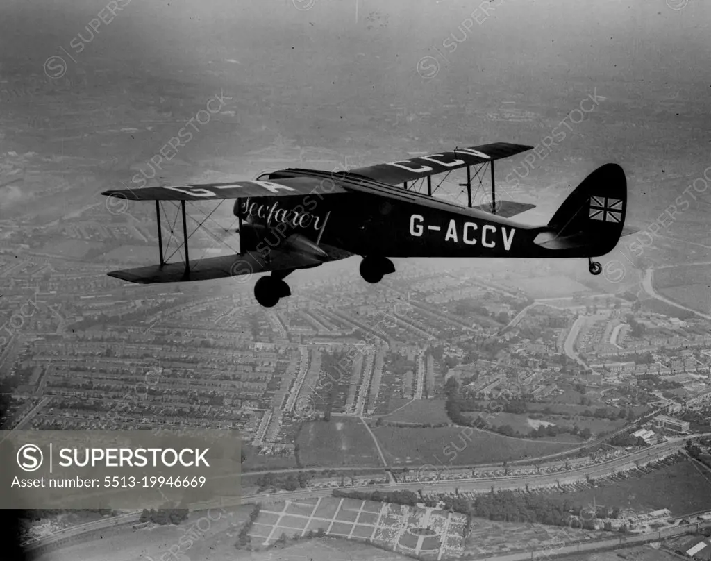 Mollisons Off To Pendine To Prepare For Big Flight -- Mr. and Mrs. Mollison's plane "Seafarer" in the air shortly after leaving Stag Lane - Picture from the air.Mr. and Mrs. J.A. Mollison took off in their black aeroplane "Seafarer" from Stag Lane Aerodrome, near London for Pendine to begin final preparations for the takeoff in the long-distance record flight attempt. The aircraft which crashed at Croydon Aerodrome when they attempted to set off a few weeks ago has been rebuilt. July 3, 1933.