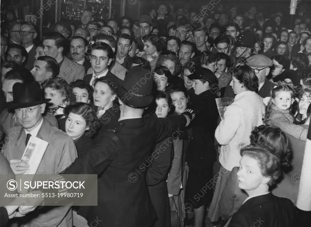 ***** -- This was London going home last night ***** the second day of the unofficial bus strike. Policemen and policewomen held hands to control the great rush-hour crowds that surged to the Tube stations because nearly a third of London's peak-hour buses were off the streets. This picture was taken at Oxford circus. October 26, 1954. (Photo by Daily Mirror).