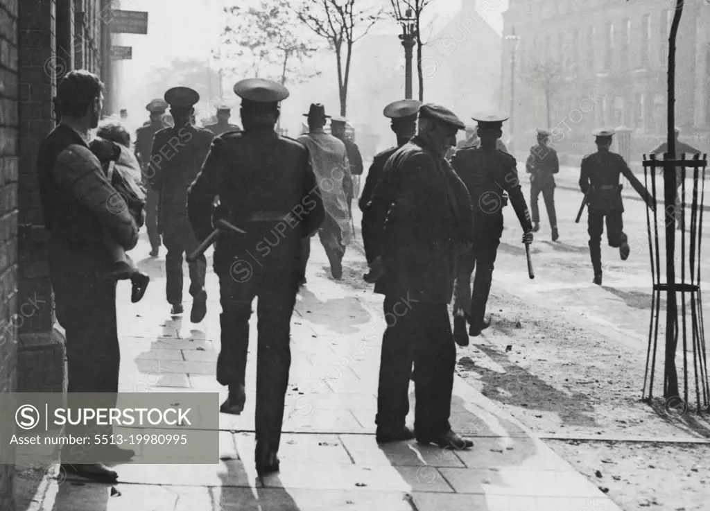 The Belfast Riots -- A baton charge at Templemore Avenue, Newtownards Road East, Belfast. It will be seen that peaceful citizens were passed by the police in pursuit of the disturbers.Two people were killed and many injured during the riots. The cause of the outbreak was owing to the police enforcing a ban on a procession of relief-work strikers who intended to carry out a mass demonstration of 80,000 to march to the Belfast workhouse. November 21, 1932. (Photo by Central News).