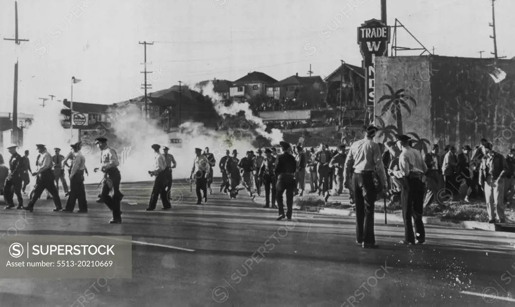 Crowd Runs As Tear Gas Let Loose -- A crowd of strikers and spectators breaksup as a tear gas bomb is let loose by police at the Standard Oil Co. refinery here today. AFL maintenance workers went through a picket line of C10 refinery workers setting off a two-hour fight between strikers and police. September 14, 1948. (Photo by AP Wirephoto)