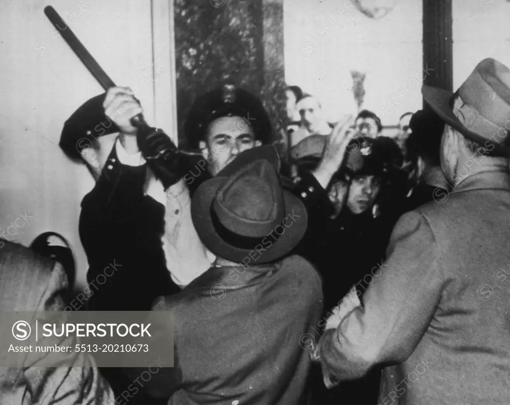 Police Officer Blocks Clubbing -- Oakland police officer grass club of special officer and cuts off attempt of special officer to swing his club as AFL unionists mass at downtown store in protest walk out here today. December 3, 1946. (Photo by AP Wirephoto).