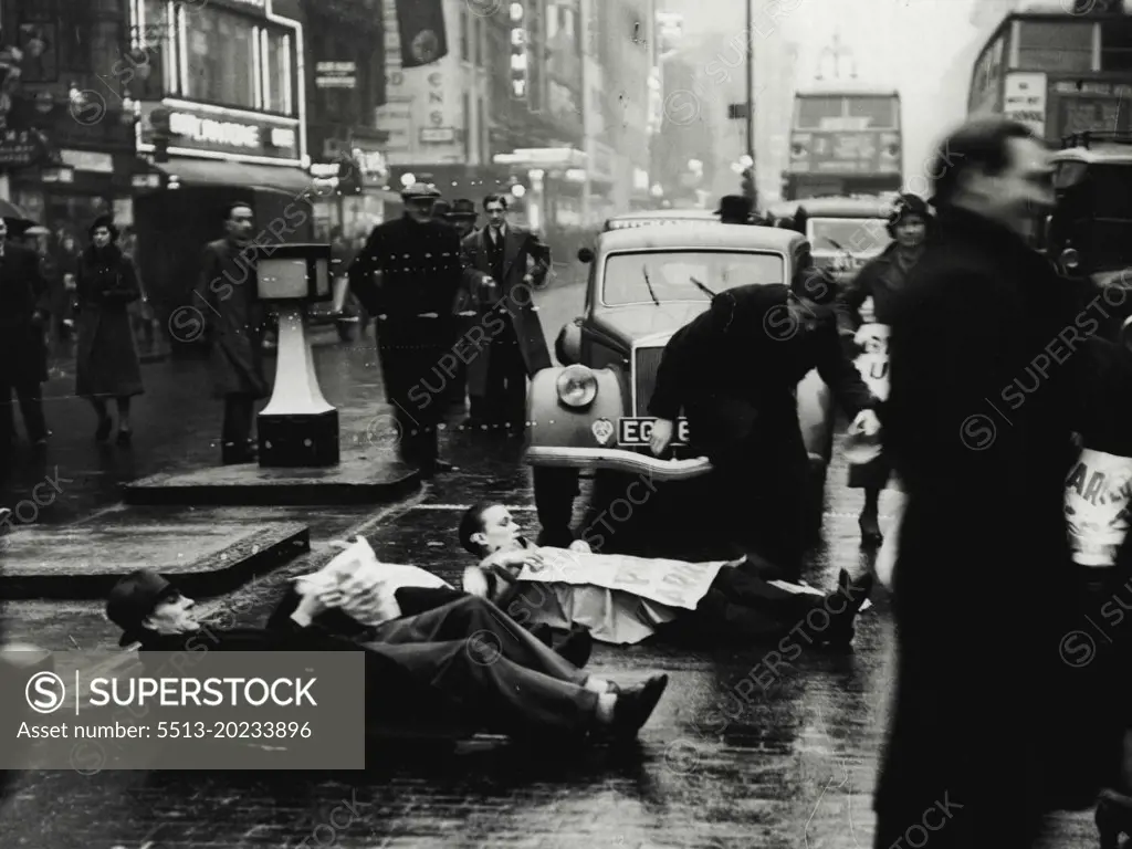 Unemployed Men Lie Down in Oxford Street -- The unemployed men lying in the road at the corner of Oxford Street and Berwick Street.Members of the Unemployed Workers Movement staged another demonstration today when they laid down in the road at the corner of Oxford Street and Berwick Street, Holding up the traffic until the police dispersed them. January 17, 1939. (Photo by Keystone Press Agency Ltd.).