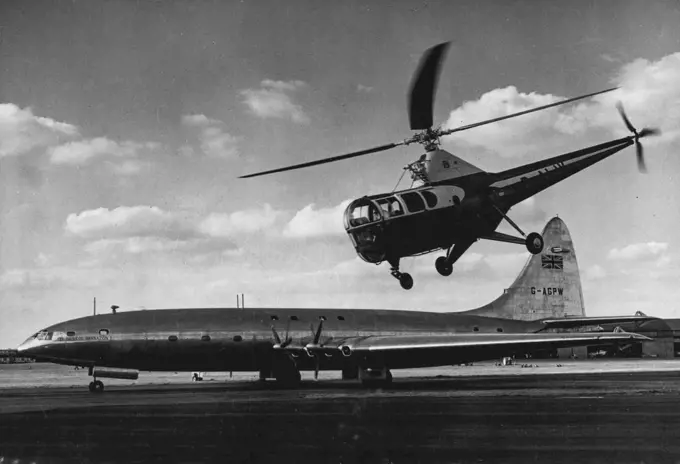 Helicopter Hovers Over Biggest Airliner -- Hovering around just like a bird a helicopter flies over the Bristol Brabazon, biggest air liner in the world, at Farnborough, Hampshire, England, where the Society of British Aircraft Constructors' display is being held. September 6, 1950.