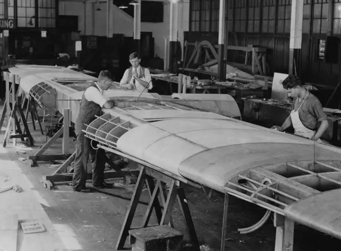 For New Zealand Flight -- Working on the wing of the Codock, the two -engined monoplane, which is being completed at Cockatoo Dock. Squadron-Leader T. W. White, on his recent arrival from New Zealand, said he expected this 'plane would be used by Sir Charles Kingsford-Smith and himself to fly to New Zealand. November 22, 1933.