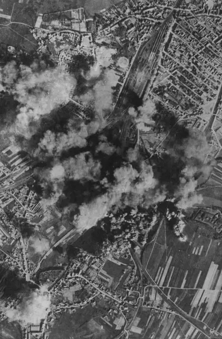 Lethal Bursts -- Heavy concentrations of bombs blossom on or near the marshalling yards at Belfort as American heavy bombers of the U.S. Eighth A.A.F. pressed home their attack on May 25th. Many hits were made on repair shops and fires started in rolling stock. May 31, 1944. (Photo by Fox Photos).