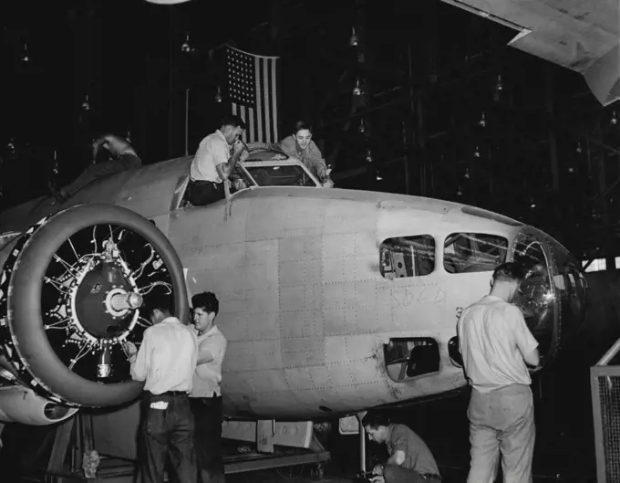 Building A Bomber -- In another picture you saw Palmer working on a plane motor. Thoroughly conversant with plane construction, He's shown above (left) working on the Windshield of a Lockheed Hudson Bomber. Note that some wag has scribbled "sold" on the fuselage, near the nose. July 18, 1941. (Photo by ACME).