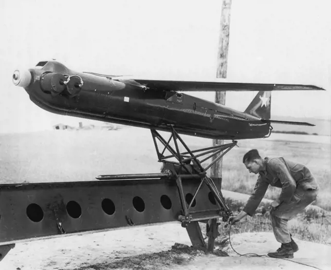 Target For Track-and-Destroy Anti-Aircraft Gun -- An "R-Cat" 300-mile-per-hour, radio-controlled target airplane is prepared for take-off at demonstration at Weybourne, England, during test of new U.S. 75mm skysweeper Anti-Aircraft gun. The new gun, demonstrated for senior British officers and reporters by the 32nd Anti-Aircraft Artillery Bridge, has built-in radar and an electronic brain that works cut speeds, heights and angles. It can fire 22 12-pounder shells in 30 seconds at aircraft flying