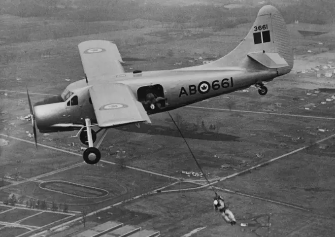 New All-Purpose Plans. A parachutist of the R.C.A.F. demonstrates one of the many uses for the new Canadian "Qtterr" all-purpose 'plane. A second parachutist can be seen just about to jump from the 'plane. The "Otter" 'plane, which has been designed and built in Canada by the De Havilland Company, for use in the Northland areas, has been officially received into service. Besides being a troop carrier, the extremely short take-off and landing space required by the "Ottar", enables it to be used f