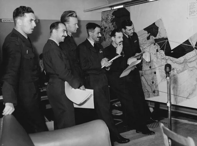 Under Starters Orders -- RAF Fliers who are taking part in the race are here seen in the briefing room at London Airport today. (Left to right) Flt. Lt. J.W. Harper of Sunderland., of Middlesex, Sqd. Ldr. L. Press of Kent., Sqd. Ldr. R. Currie of Manchester and Flt. Lt. R.M. Furze, of Herts. Lined up under starters orders, entrants for the London- New Zealand air-force were on show to the public at London Airport today. Although the instruments have been sealed in readiness for the race which st