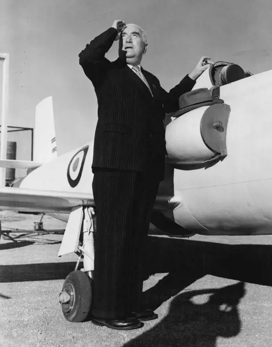 The Prime Minister (Mr. Menzies) leans against a Jindivik and watches a RAAF Metero jet fighter, which controlled the Jindivik by radio in a flight test. May 01, 1953.