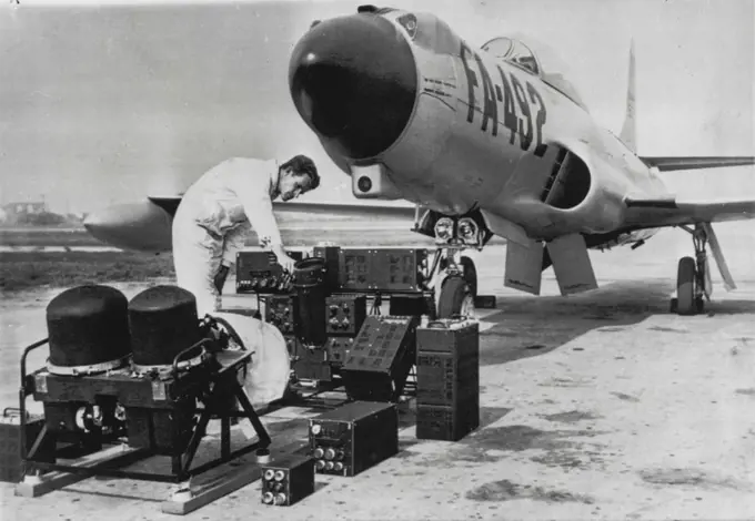 'Brain Lobes' of Electronics Seek And Destroy System -- On ground in front of this F-94 interceptor plane are the different parts of the electronic brain used in the "seek-find-and-kill" system which enables an interceptor to locate enemy aircraft at long range, regardless of visibility, direct the pilot to the target and launch the armament at the correct instant. Secret of how it is done was revealed today at the Hughes Aircraft Co., Culver City, Calif. October 05, 1955. (Photo by AP Wirephoto