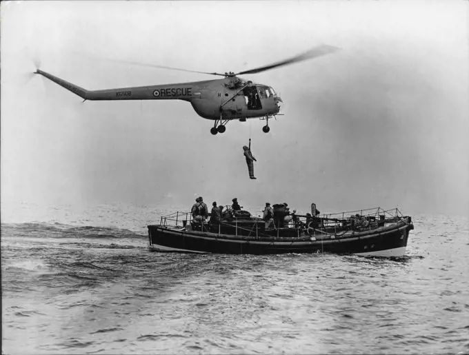 Rescued From The North Sea -- An airman is put aboard the Broughty Ferry lifeboat after being picked up, from the sea by the helicopter. Eleven men were rescued from drifting dinghies in the bleak waters of the North Sea recently. The rescued men were not however genuine but human guinea-pigs in a helicopter rescue demonstration, 15 miles off tayport. The exercise was performed by members of 275 search ***** because squadron, one of the only two ***** in Great Britain, and based *****. December 