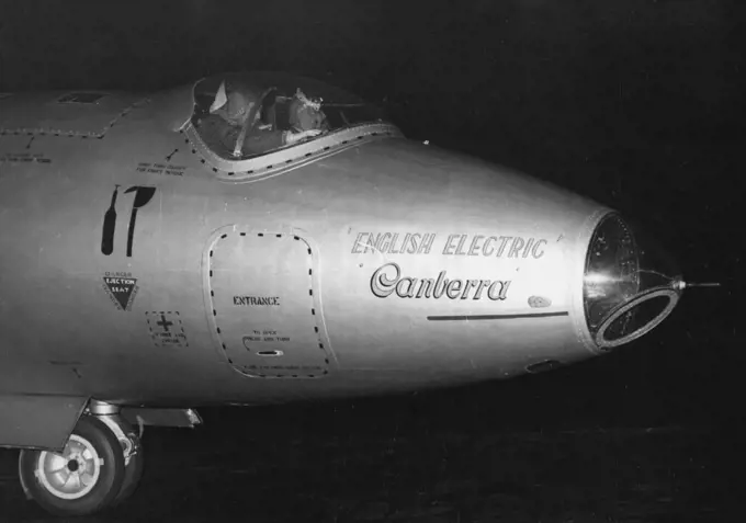 London-New York and Back In 14½ Hours -- The records-making Canberra taxis across a London Airport runway last night on its return from New York. Navigator Moneypenny is nearest camera. A silver-painted English Electric Canberra Jet Bomber roared over London last night after a 14½-hour flight to New York and back, during which it established three speed records. The plane-piloted by Moustached John Hacktt and navigated Peter Moneypenny took off at 7.10 A.M. and arrived home again at 9.41 P.M. 