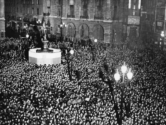 How London Welcomed The New Year -- The super-electronic photo flash lights up London's Piccadilly Circus and the camera catches the midnight scene as crowds welcomed 1951 Rain turned to sleet and put a damper on the celebrations in London but there was still a crowd round the Eros Statue in Piccadilly. January 1, 1951. (Photo by Paul Popper Ltd.).;How London Welcomed The New Year -- The super-electronic photo flash lights up London's Piccadilly Circus and the camera catches the midnight scene a