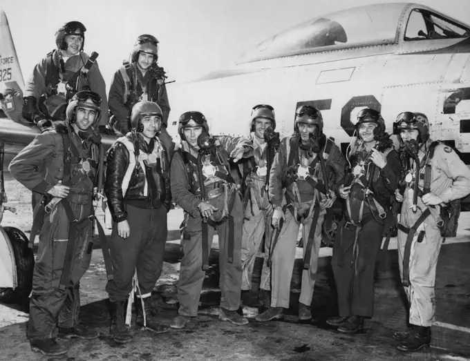 Mig Victors: An Airbase In Japan -- A group of happy young F-84 Thunder jet pilots of the Fifth Air Force's 27th Fighter Escort Group smile broadly. They have just returned from the, greatest aerial battle of the Korean war, in which about 115 F-84 Thunder lets and F-86 Sabrejets of the Fifth Air Force tangled with 80 enemy MIC-15 type fighter which tried to intercept, a large formation of B-29 Superforts April 12 near the Yalu River in North Korea. During a fierce, high-altitude battle, more th